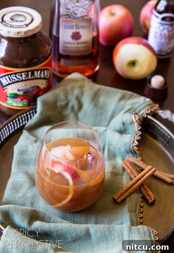 Harvest Apple Old Fashioned 3 Apple cinnamon old fashioned cocktail on a serving platter with garnish of apple and cinnamon stick.