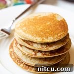 Primal Flapjacks 3 A vibrant close-up of a stack of fluffy paleo pancakes.