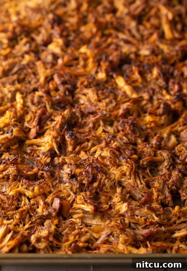 Crispy Pork Carnitas Made Easy 8 Broiled shredded carnitas on a baking sheet, displaying perfectly crispy and browned edges.