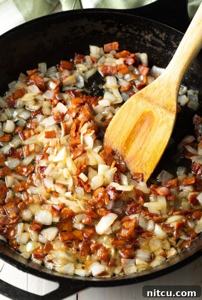 Emerald Spud Pie 4 Crispy bacon and sliced onions sautéing in a hot pan, filling the kitchen with an inviting aroma.