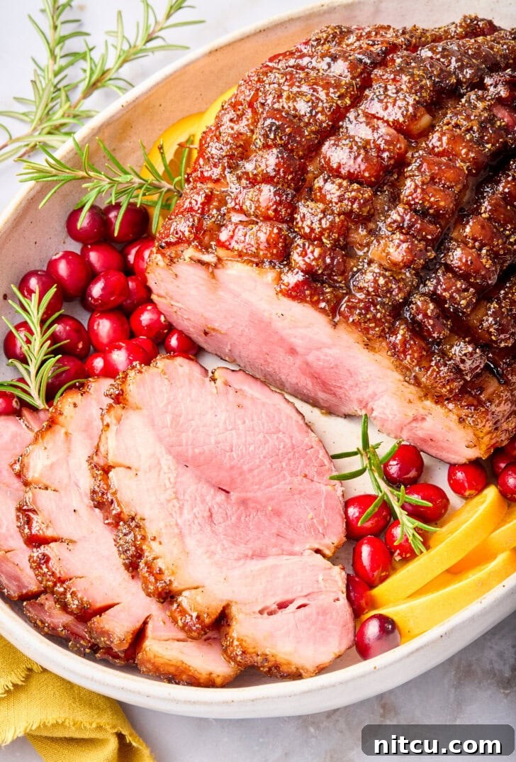 Caramelized Brown Sugar Glazed Ham 4 A large baked ham, beautifully glazed and partially sliced, presented on a serving platter, showing its juicy interior and caramelized crust.