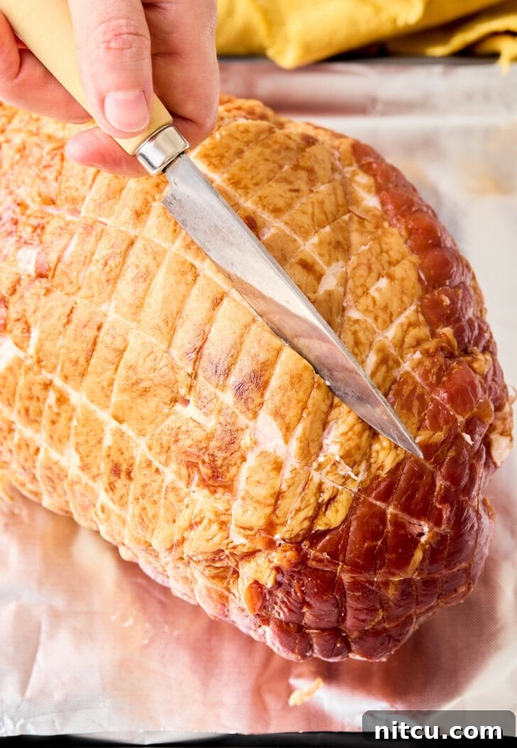 Caramelized Brown Sugar Glazed Ham 7 A chef carefully scoring a diamond pattern onto the surface of a raw ham with a sharp knife, a crucial step to allow the glaze to penetrate deeply and create a beautiful presentation.