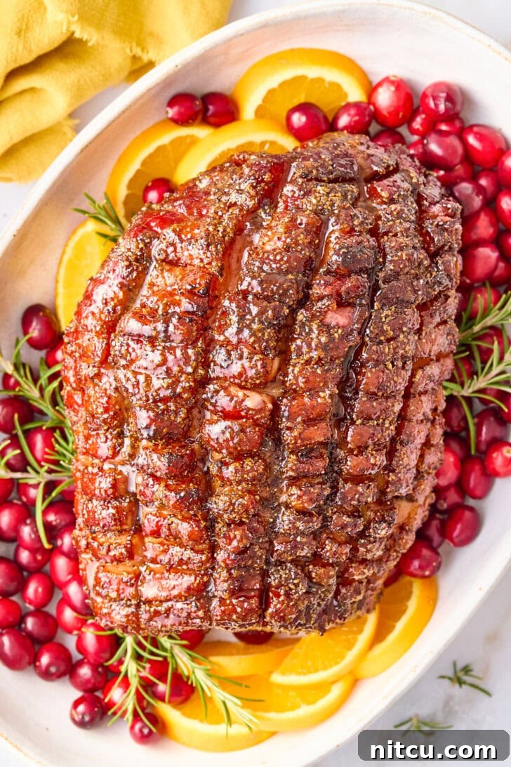 Caramelized Brown Sugar Glazed Ham 10 A fully baked Thanksgiving ham with brown sugar glaze, artfully arranged on a platter, adorned with fresh orange slices, vibrant cranberries, and aromatic herbs, creating a stunning visual display.