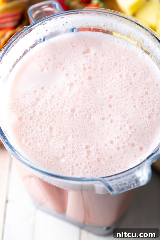 Crafting Refreshing Agua Fresca 6 Blended frothy pink agua fresca in a blender jar.