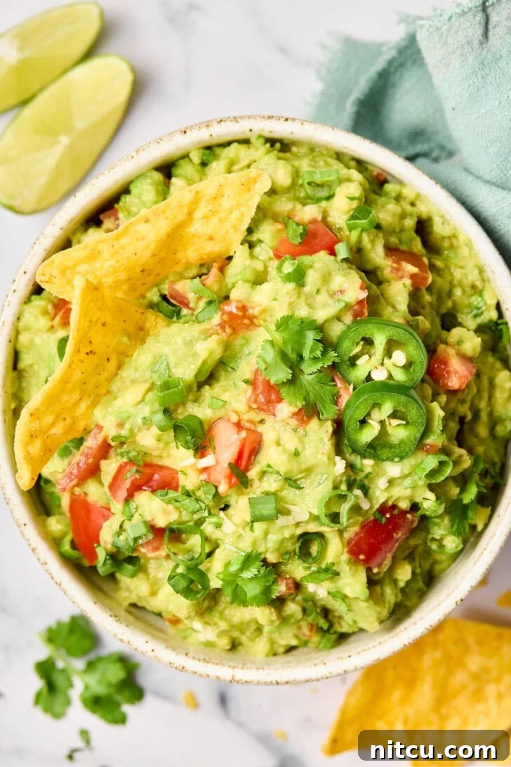 Heavenly Guacamole Perfection 3 Top-down view of a bowl of guacamole surrounded by tortilla chips, ready to serve.