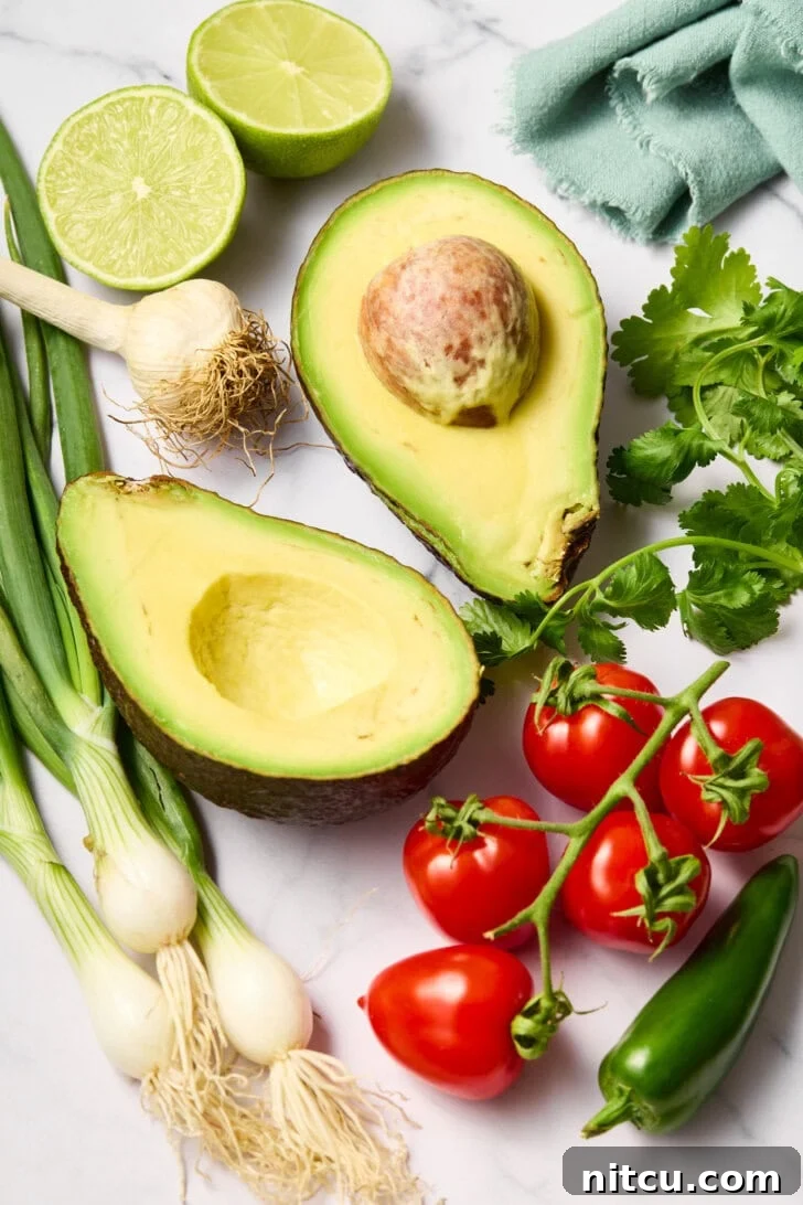 Heavenly Guacamole Perfection 5 All the fresh ingredients for guacamole laid out on a kitchen counter.