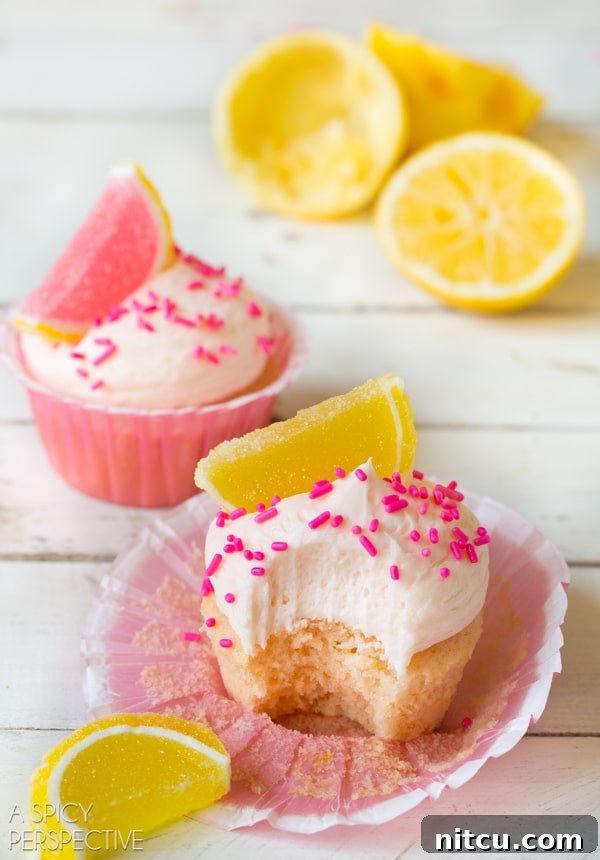 Zingy Pink Lemonade Cupcakes, topped with sprinkles for extra fun. #lemon #lemonade #cupcakes #pink #kitchenconvo