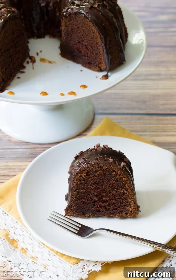 Irish Cream Dream Bundt 5 A delectable slice of Baileys Irish Cream Bundt Cake, revealing its soft, moist crumb and the perfect balance of chocolate and cream, served with a fork.