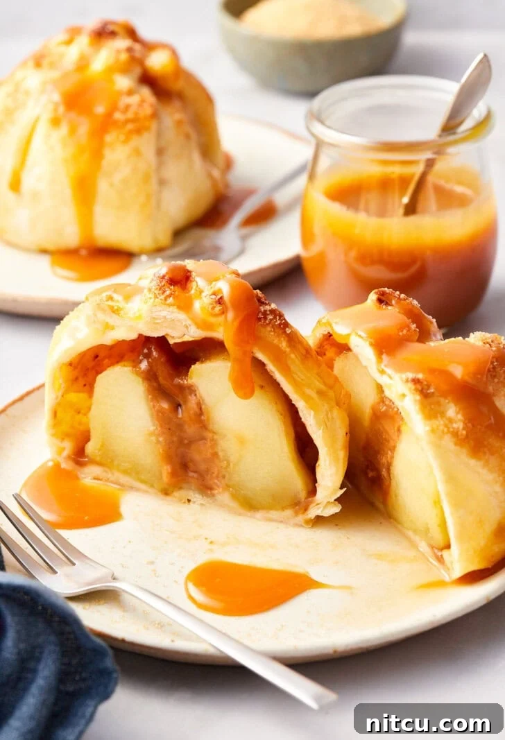 Flaky Apple Pastry Pockets 5 Simple baked apples in puff pastry on a plate, cut in half.