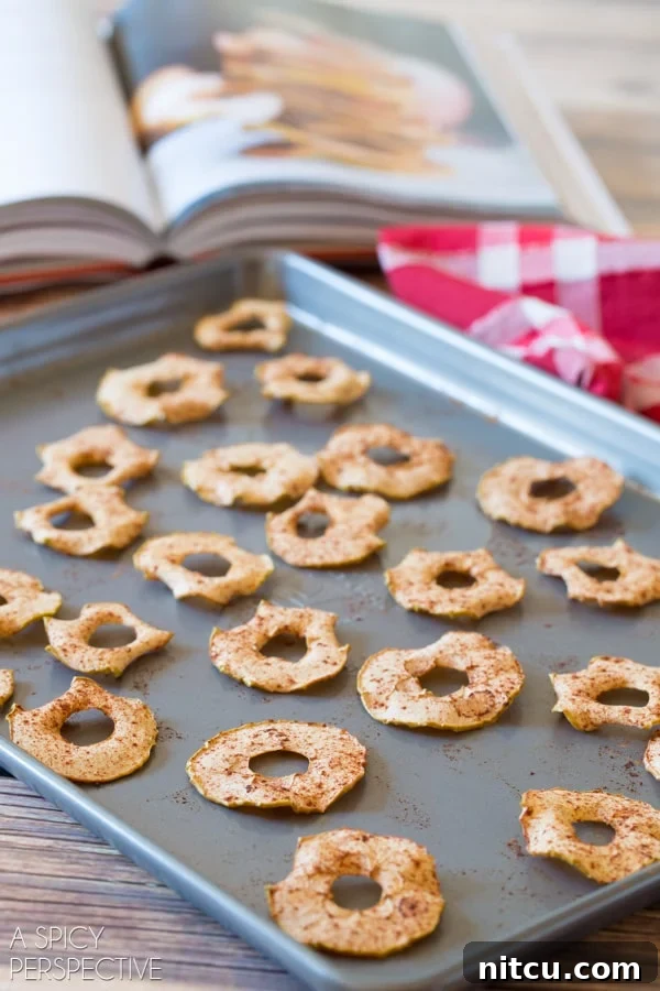 Golden Apple Crisps 5 Side view of baked apple chips on a baking sheet.