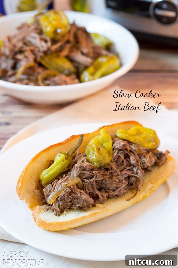 Perfect Slow Cooker Italian Beef 2 Italian Beef Recipe piled high in sub rolls, ready to be enjoyed as sandwiches