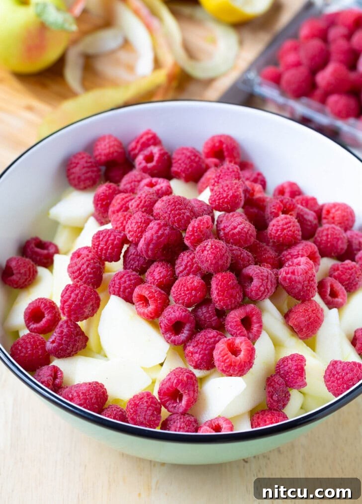 Berry Kissed Apple Pie 4 Bowl filled with sliced apples and fresh raspberries, tossed together for the pie filling.