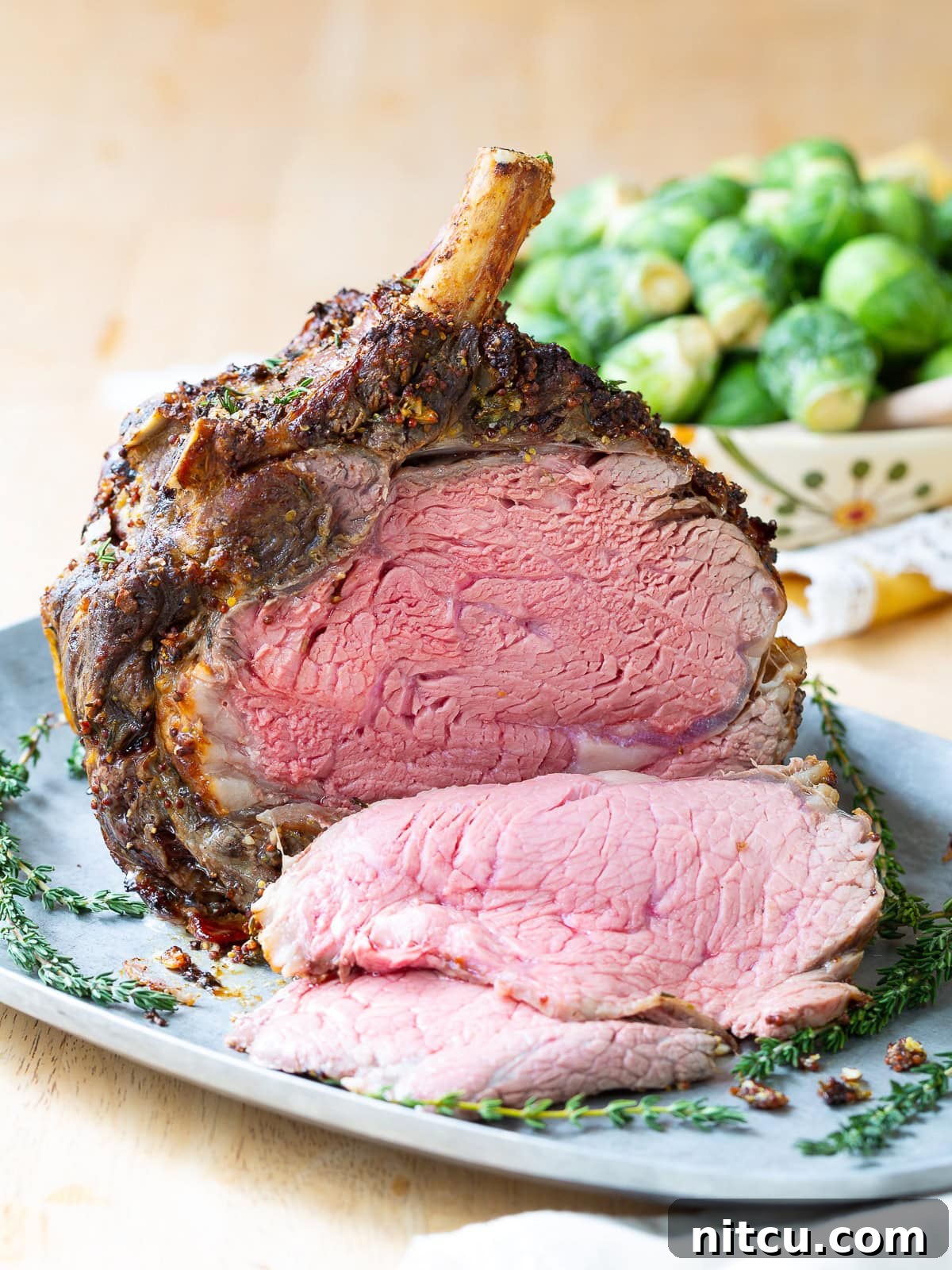 The Grand Prime Rib Roast 7 Close-up side view of several slices of prime rib, showcasing the beautiful pink, juicy center and crispy crust.