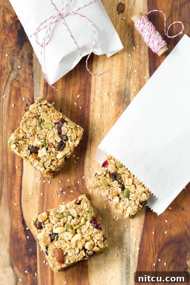 Square homemade granola bars on a wooden cutting board.