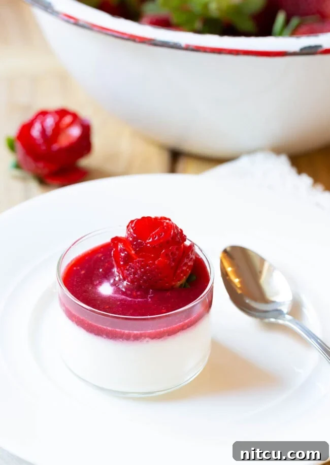 Small glass dish with silky Swedish Cream topped with luscious berry compote and an artfully crafted strawberry rose.
