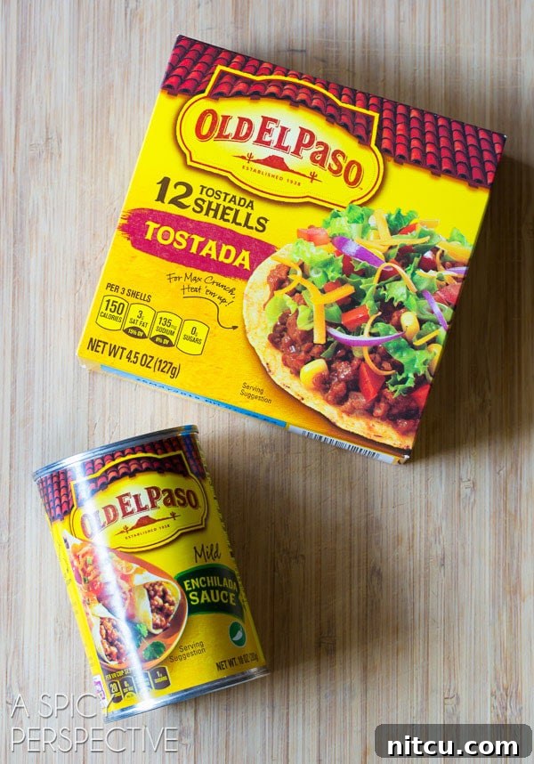 A close-up of Old El Paso ingredients for slow cooker chicken tortilla soup, showing a box of gluten-free tostada shells and a can of mild red enchilada sauce, ready for preparation.