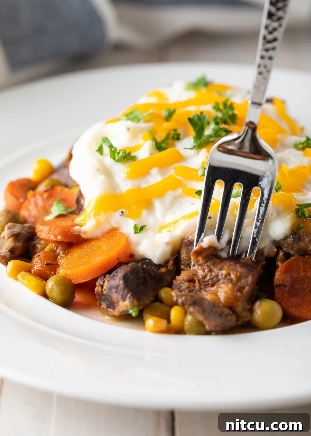 Fork taking a bite of crockpot shepherd's pie. 