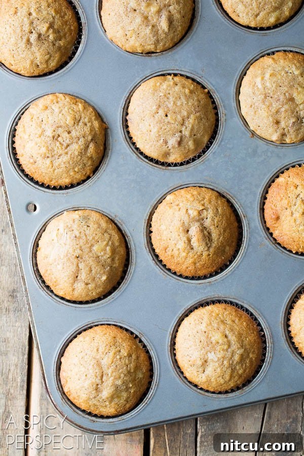 Luscious Hummingbird Cupcakes 5 Freshly baked Hummingbird cupcakes rising perfectly in a muffin tin, golden brown and ready to cool.