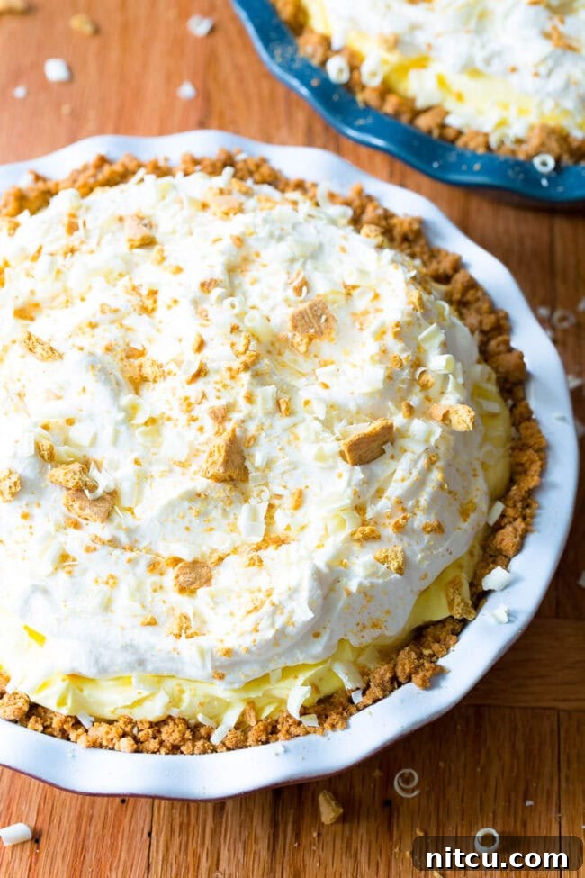 Luscious Lemon Cream Pie 2 Close up shot of lemon cream pie in a white pie dish.