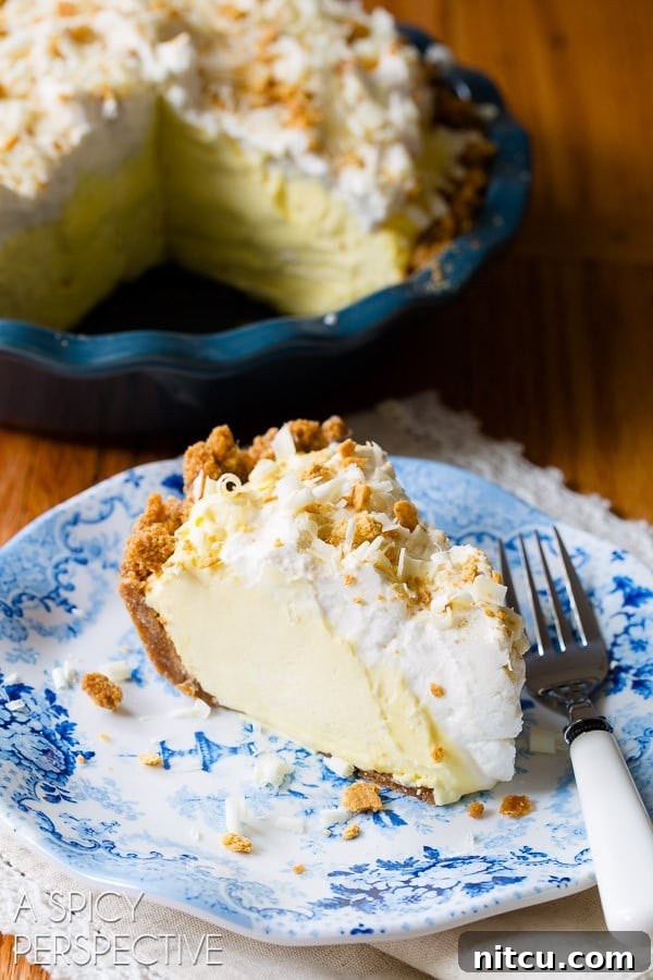 Luscious Lemon Cream Pie 4 Slice of silky lemon cream pie on a plate with a fork.