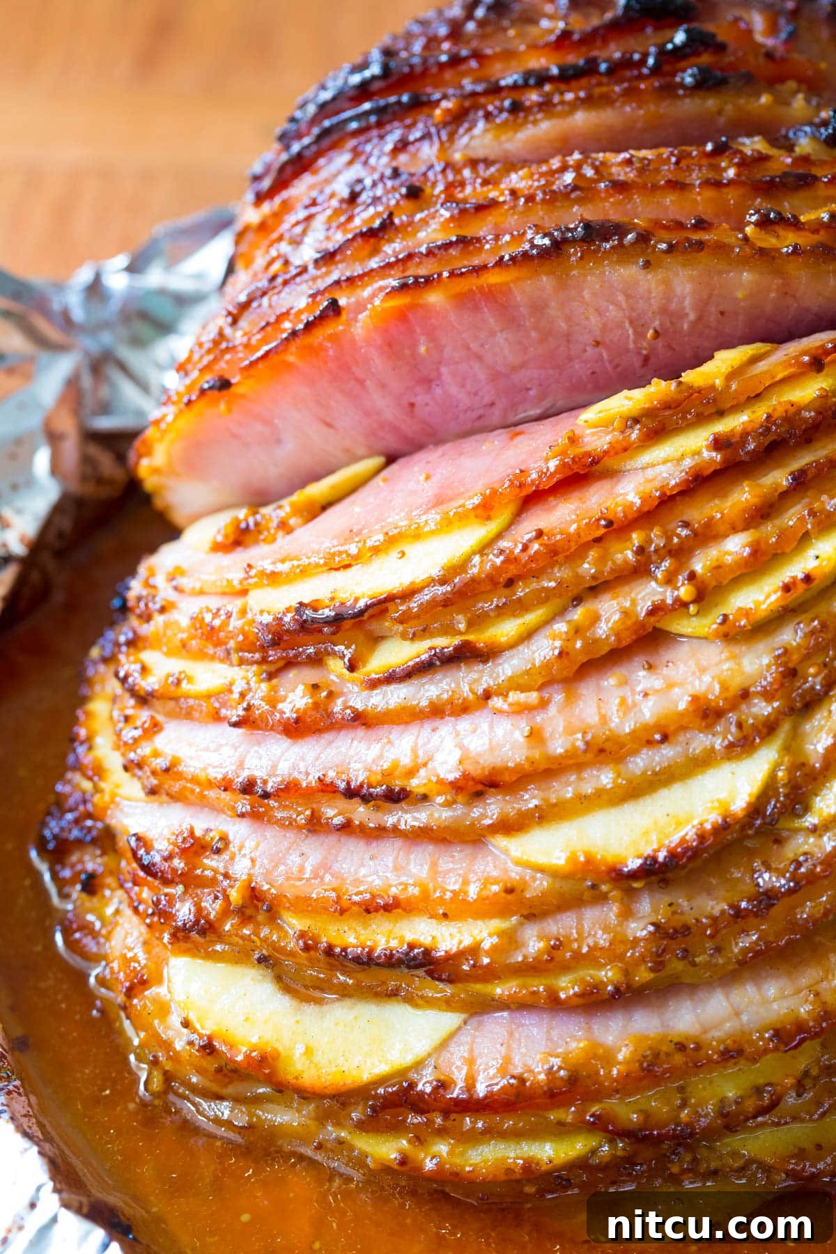Honey-Glazed Ham with Roasted Apples 11 A vibrant close-up of the spiral ham showing the meticulously tucked apple slices and the rich, golden-brown glaze, ready to be carved.