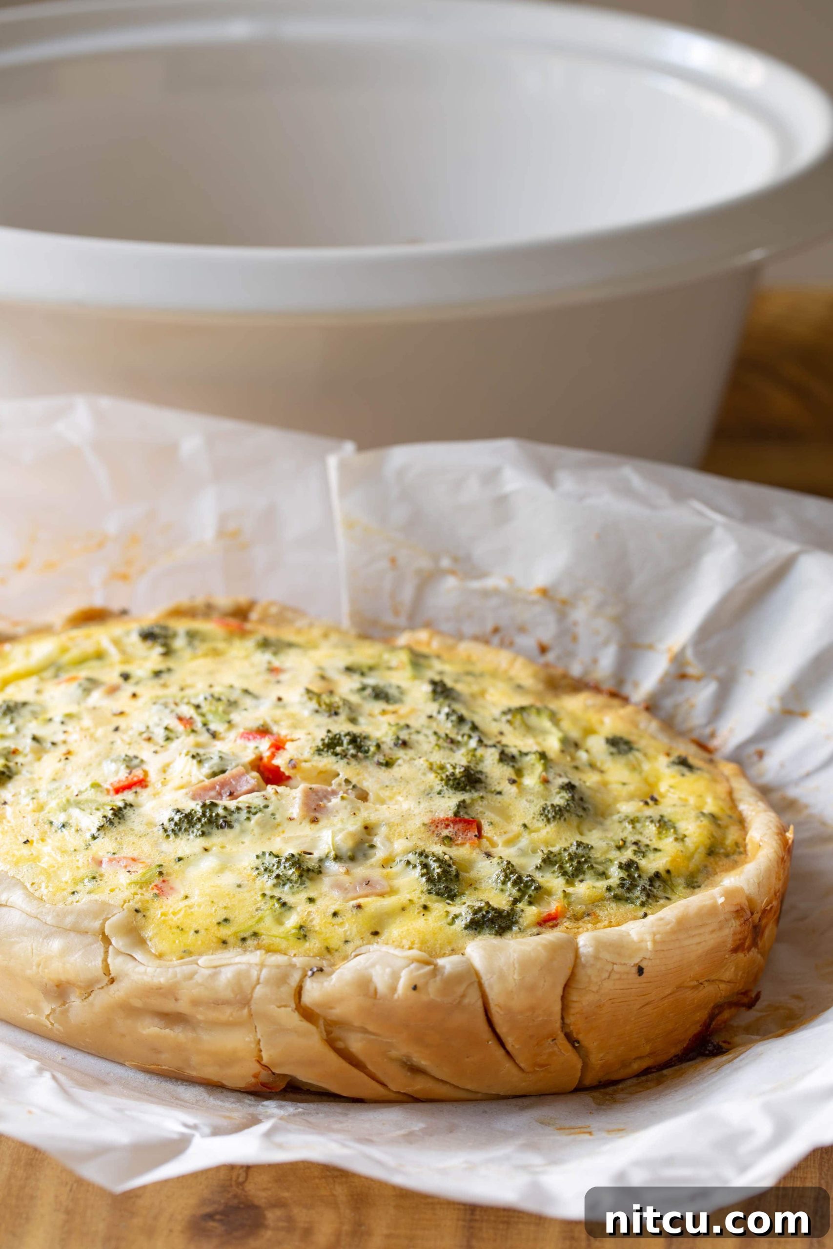 Cooked breakfast quiche on a piece of parchment paper.