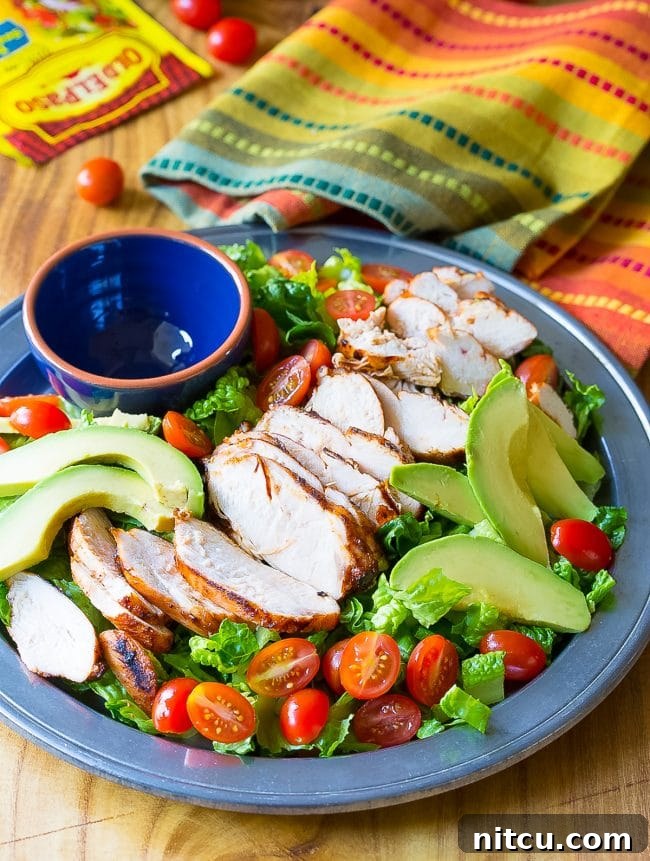 Fiesta Chicken Salad 4 Loaded Mexican grilled chicken salad on a platter with an empty ramekin.
