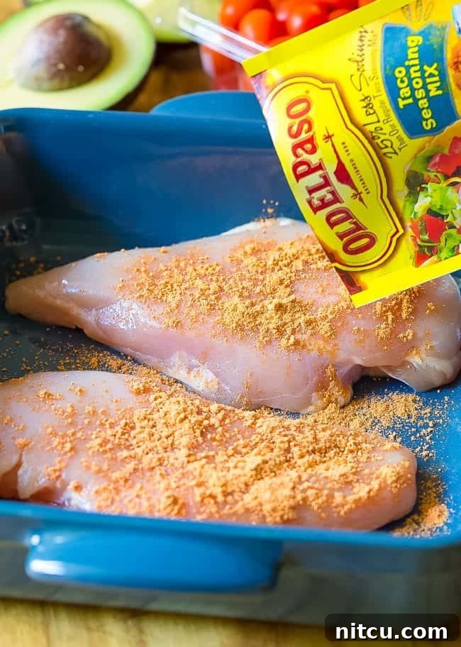 Fiesta Chicken Salad 5 Raw chicken breast in a platter being seasoned with Old El Paso Taco Seasoning.