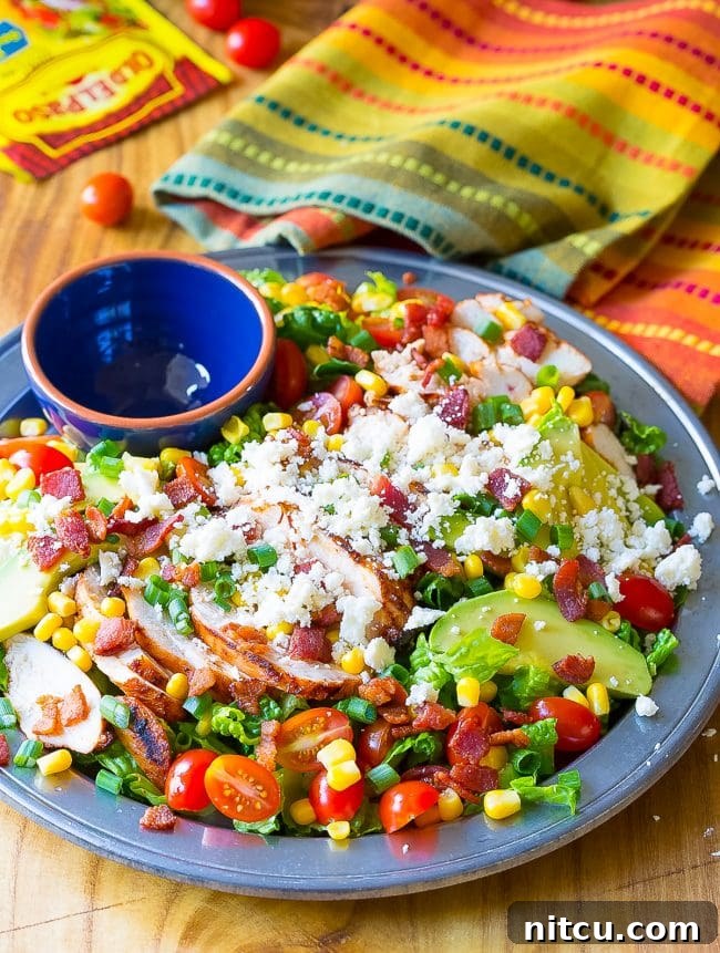Chicken Salad #ASpicyPerspective #GrilledChickenSalad #GrilledChicken #Salad #MexicanSalad #ChickenSalad #MexicanChickenSalad #MexicanGrilledChickenSalad Mexican Chicken Salad with chicken, bacon, corn, tomatoes, avocado and queso fresco on a large plate.