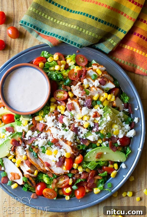 Fiesta Chicken Salad 8 Overhead shot of large platter filled with completed Mexican grilled chicken salad and a ramekin filled with dressing.