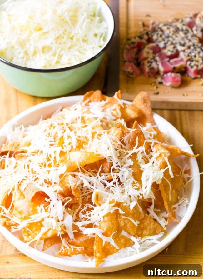 Aloha Ahi Poke Nachos 10 Wonton chips on a white plate topped with shredded cabbage.