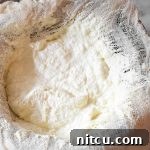 A delicious glass jar of homemade ricotta cheese, ready to be enjoyed.