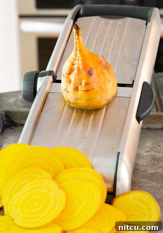 Wholesome Beet Crisps 4 Beets being sliced on a mandoline slicer. Achieving uniform thinness.