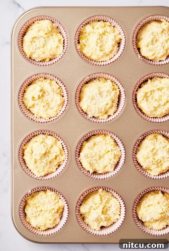 Tropical Sunrise Muffins 7 Muffin batter scooped into the cups of a muffin tin.