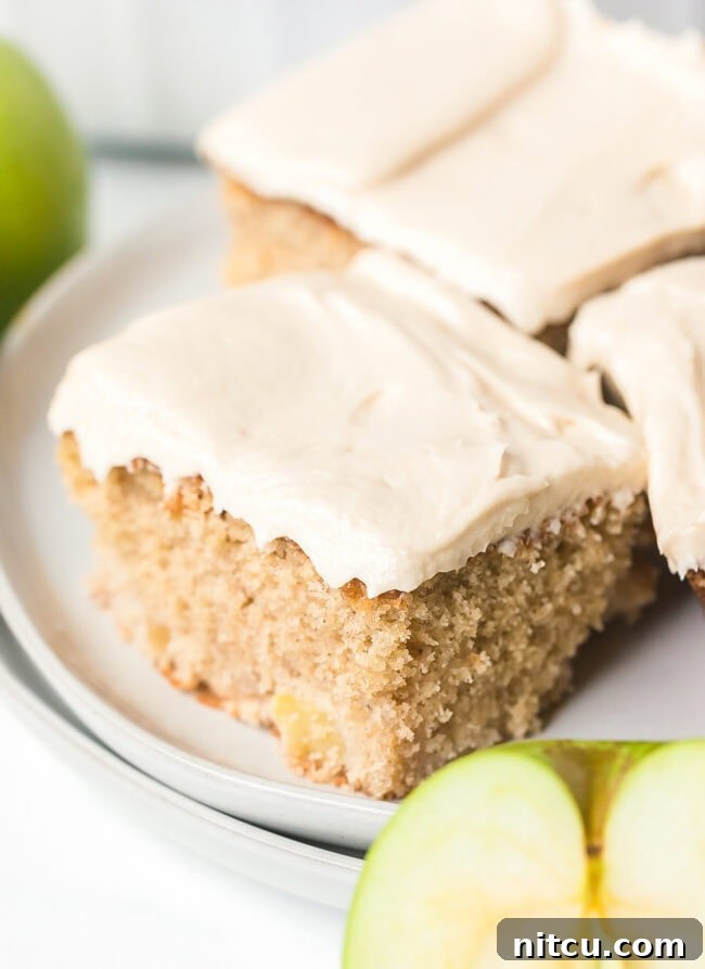 A freshly baked apple sheet cake, cooled and perfectly cut into squares, ready to be frosted.