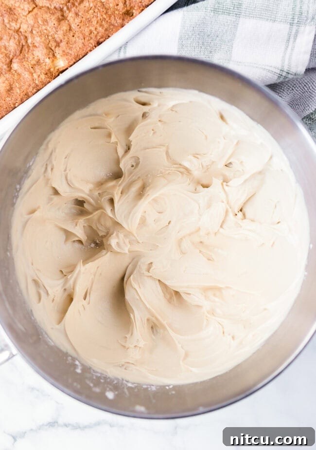 Salted caramel frosting in the bowl of an electric mixer, perfectly whipped and ready to be spread.