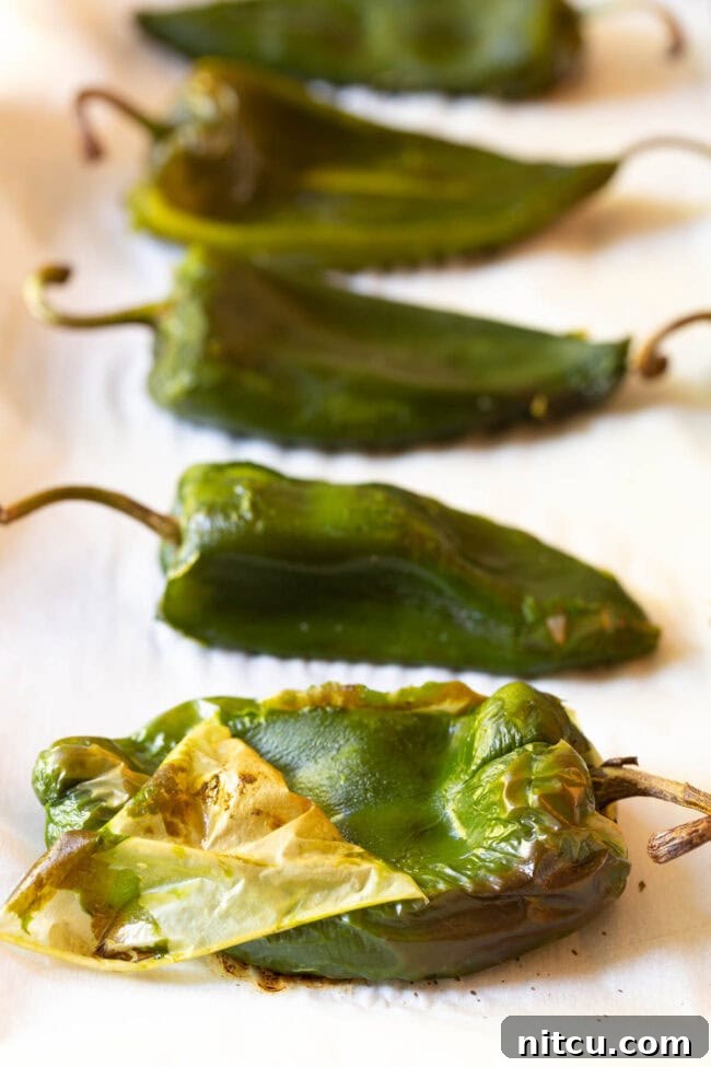 Peeling the skin off of roasted poblano peppers.
