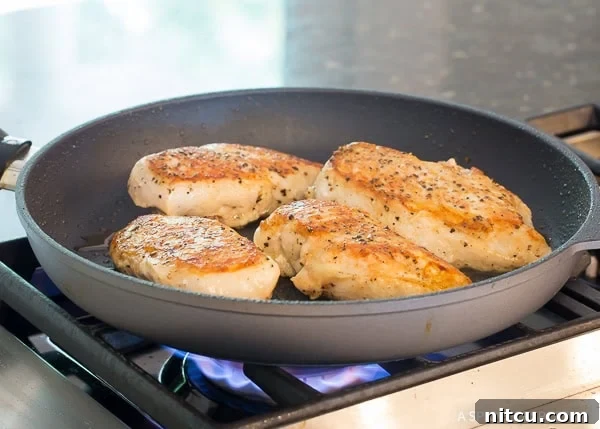 Zesty Garlic Lime Chicken 4 Chicken breast being seared in a cast iron skillet, acquiring a golden crust.