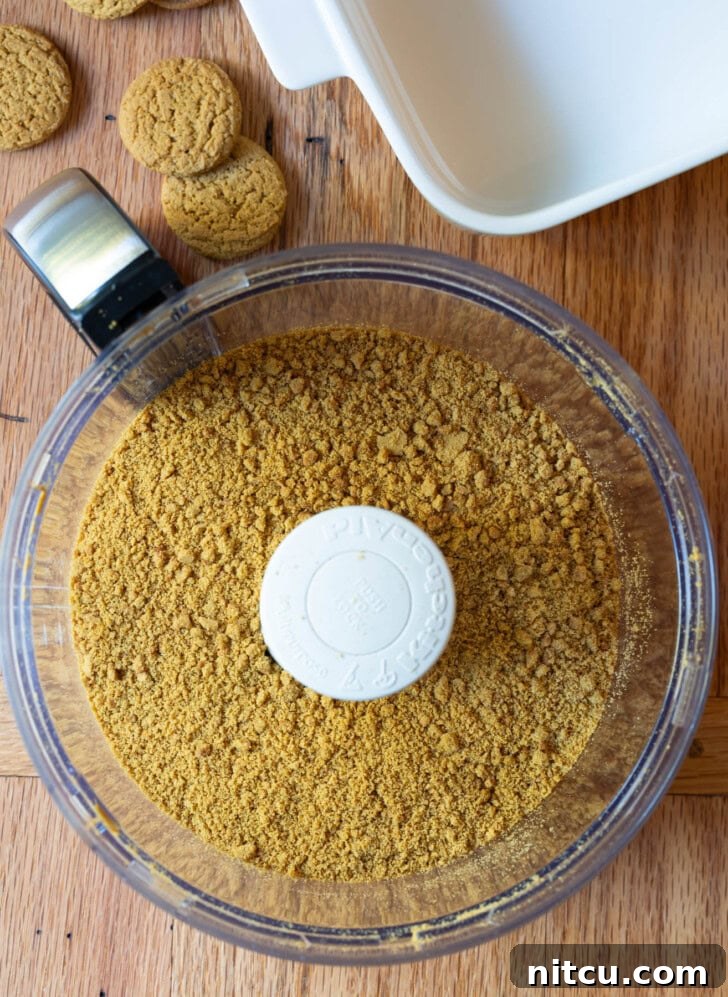 Spiced Pumpkin Cheesecake Squares 4 Gingersnap crumbs, sugar, and melted butter combining in a food processor for the crust.