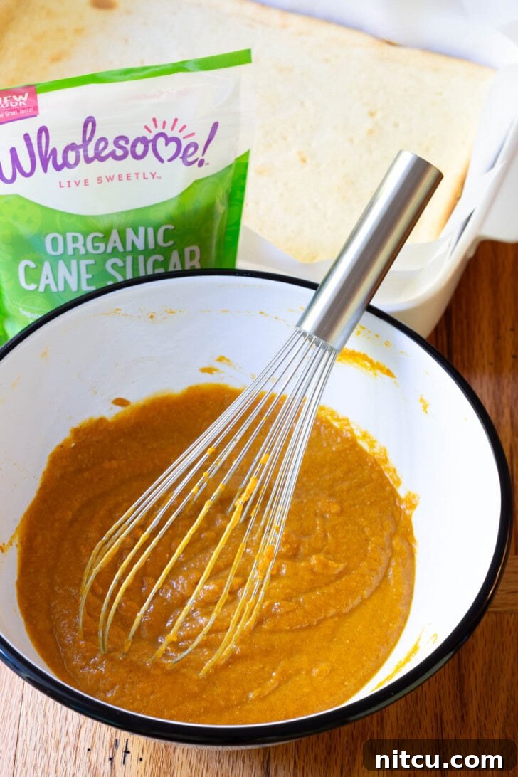 Spiced Pumpkin Cheesecake Squares 7 Pouring the spiced pumpkin mixture over the cooled cheesecake layer.