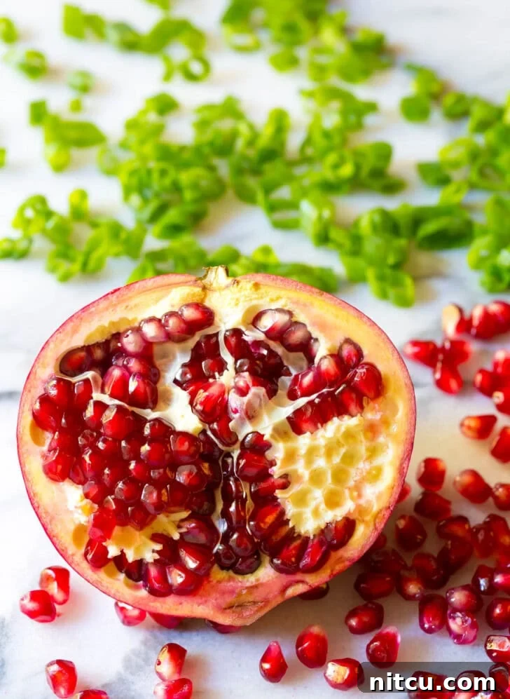 Wholesome Lentil Salad with Tangy Apple Dressing 3 Half of a pomegranate with the seeds popping out.