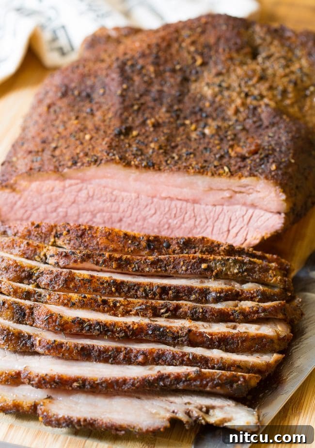 Perfect Oven Brisket 2 Oven Brisket on a cutting board with slices off the side.