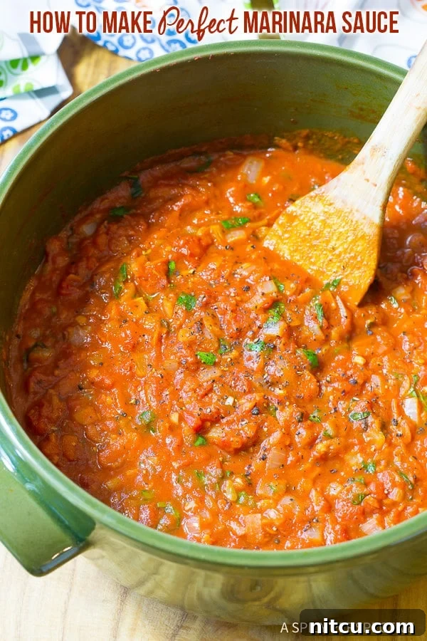 A vibrant green pot filled with simmering, perfect homemade marinara sauce, garnished with fresh basil leaves.