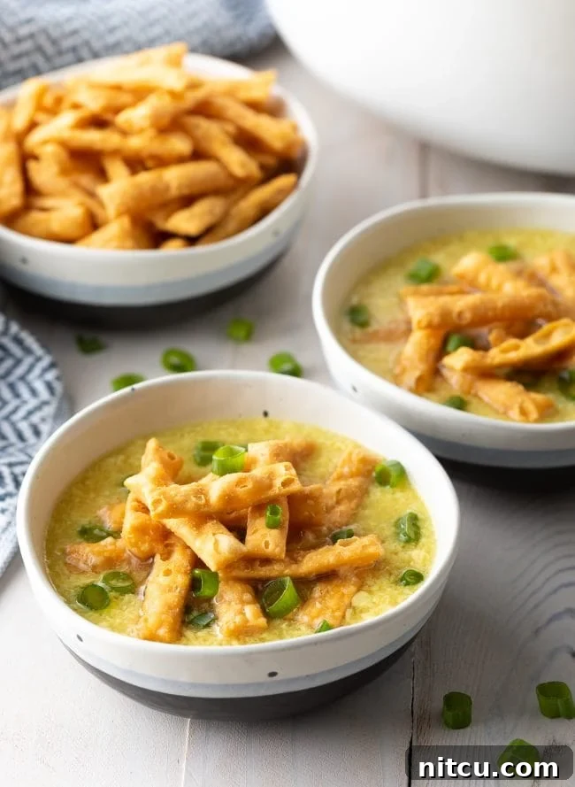 Cozy Kitchen Egg Drop Soup 2 Two bowls of egg drop soup topped with crispy noodles and slice green onions.