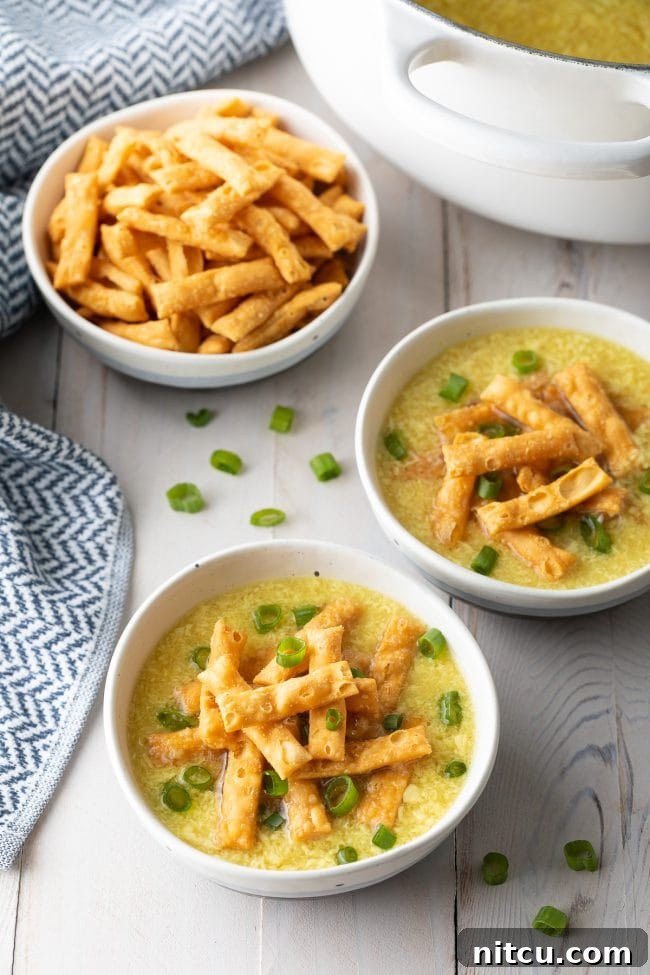 Cozy Kitchen Egg Drop Soup 8 Two bowls of egg drop soup topped with crispy noodles and slice green onions.