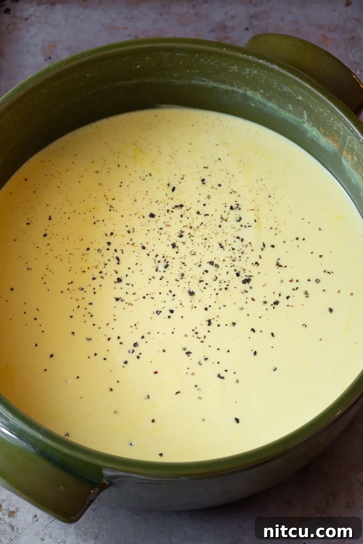 Irish Beer Cheese Soup simmering gently in a large pot on the stovetop.