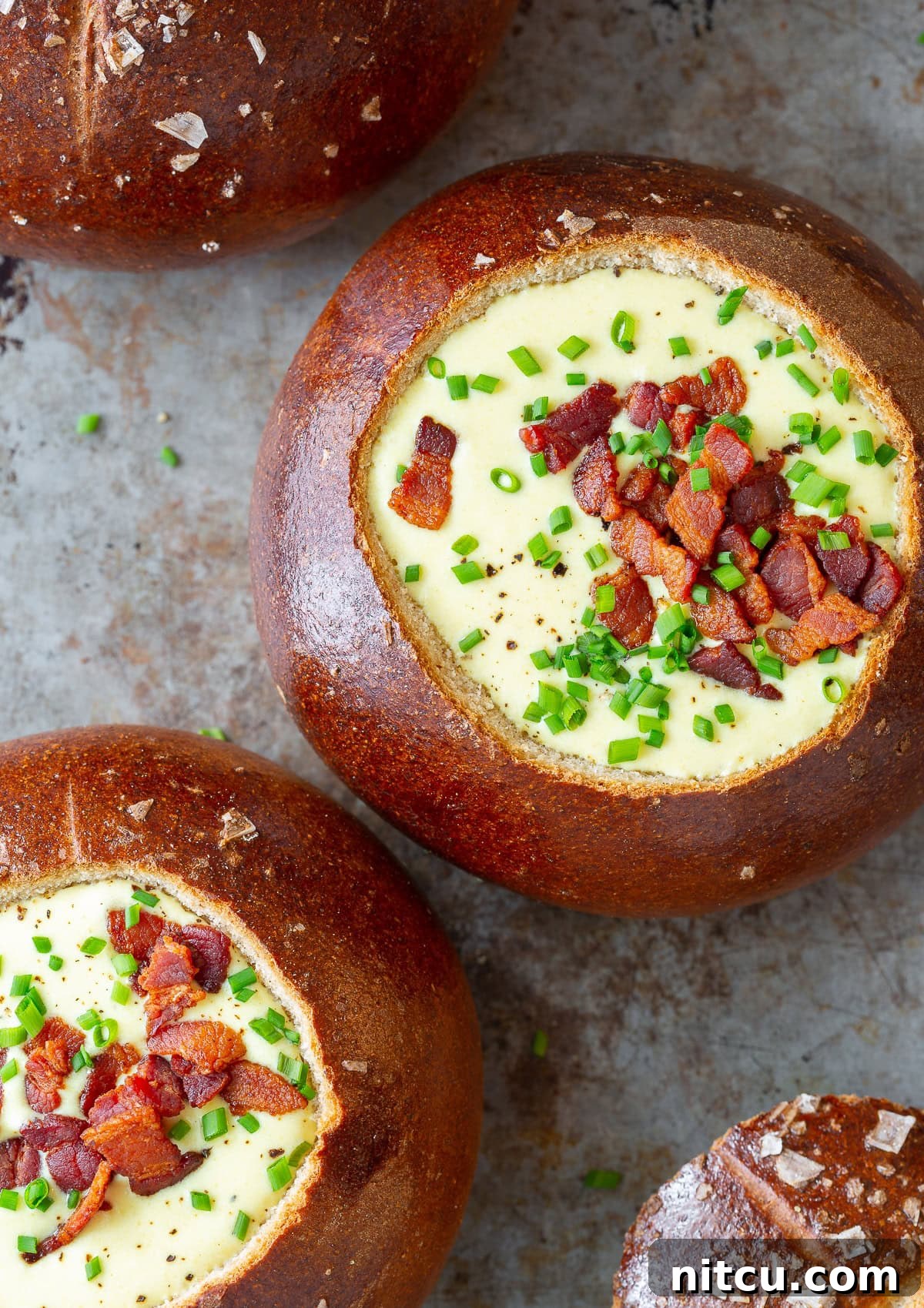 Overhead view of two bread bowls overflowing with creamy Irish Beer Cheese Soup.
