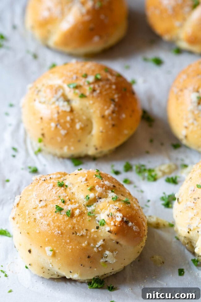Effortless Garlic Knots 3 Garlic knots neatly lined up on a baking sheet, ready for baking.