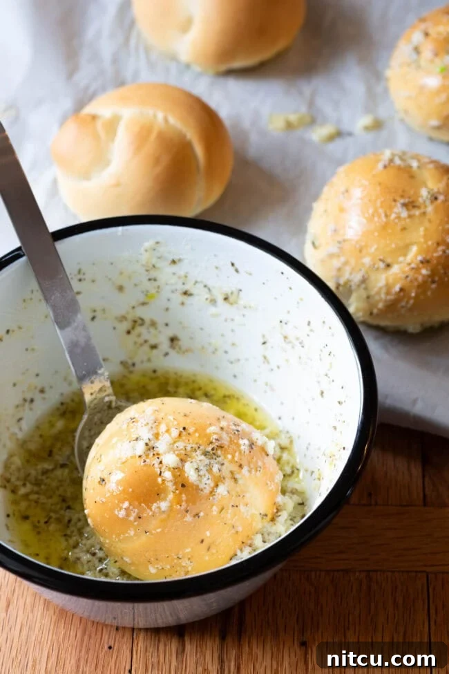 Effortless Garlic Knots 9 A close-up of a freshly baked garlic knot being dunked into a bowl of rich, melted garlic butter, ensuring every crevice is coated.