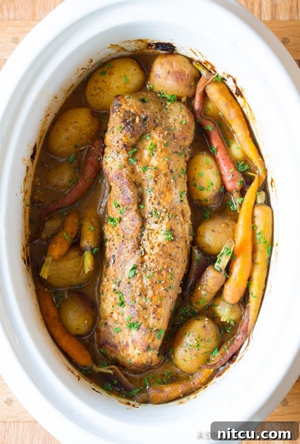 Melt-in-Your-Mouth Slow Cooker Pork Loin and Root Veggies 2 Crock Pot Pork Loin with potatoes, carrots, and onions in a rich, tangy gravy